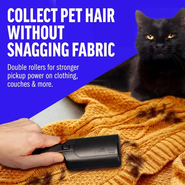 A close-up of a hand using a black reusable roller to clean black cat fur off a yellow knitted sweater